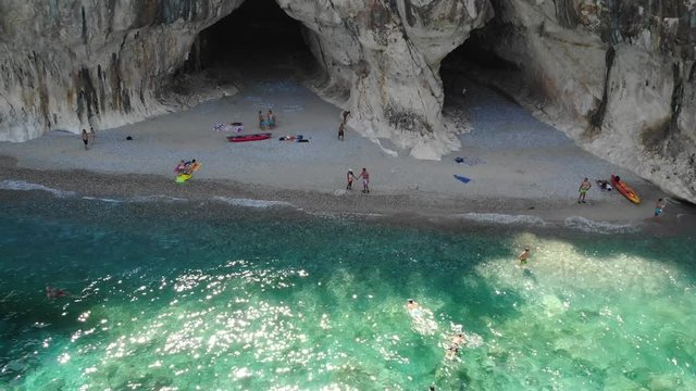 Aerial view Cala Luna beach, Young couple on vacation on the Italian Island of Sardinia, Cala Gonone Orosei coast , men and woman on the beach relaxing in the sun