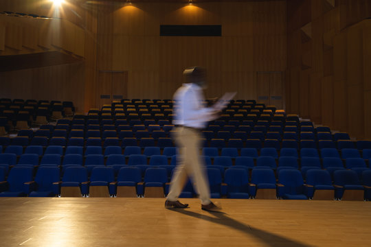  Businessman practicing and learning script while walking in the auditorium