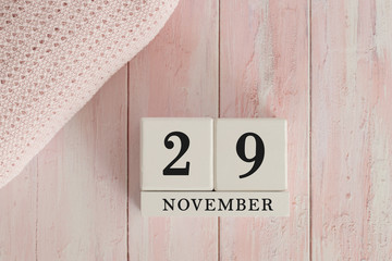 29 November Date on Cubes. Date on painted pink wood, next to baby blanket. Theme of baby due dates and birth dates.
