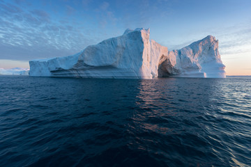 Naklejka na ściany i meble Huge icebergs of different forms in the Disko Bay, West Greenland. Their source is by the Jakobshavn glacier. This is a consequence of the phenomenon of global warming and catastrophic thawing of ice