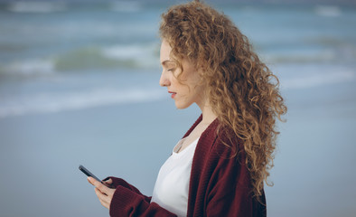 Woman using mobile phone at beach