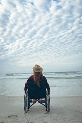 Woman disbale sitting on wheelchair at beach 