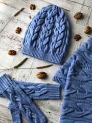 blue set of hand-knitted: hat, mittens, scarf with orange, dry rose, almonds, herbs. the view from the top