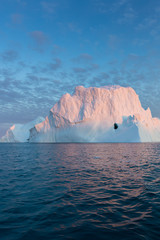 Fototapeta na wymiar Huge icebergs of different forms in the Disko Bay, West Greenland. Their source is by the Jakobshavn glacier. This is a consequence of the phenomenon of global warming and catastrophic thawing of ice
