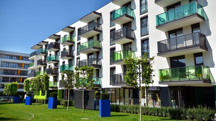 Contemporary residential building exterior in the daylight. Modern apartment buildings on a sunny day with a blue sky. Facade of a modern apartment building