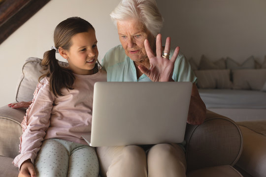 Grandmother and granddaughter discussing over laptop