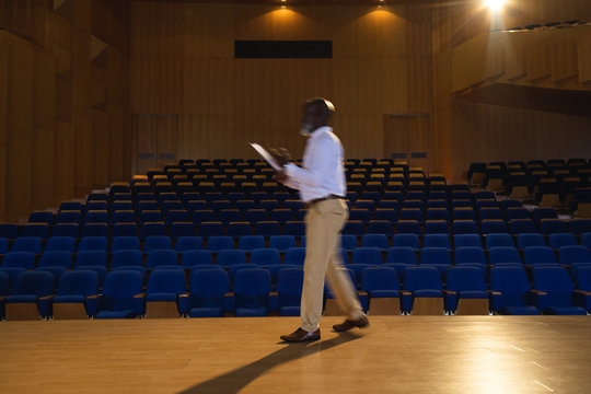 Businessman practicing and learning script while walking in the auditorium