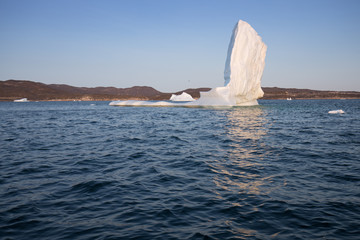 Fototapeta na wymiar Huge icebergs of different forms in the Disko Bay, West Greenland. Their source is by the Jakobshavn glacier. This is a consequence of the phenomenon of global warming and catastrophic thawing of ice