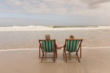 Senior couple holding hands of each other at the beach