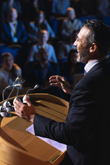 Businessman standing and giving presentation in the auditorium 