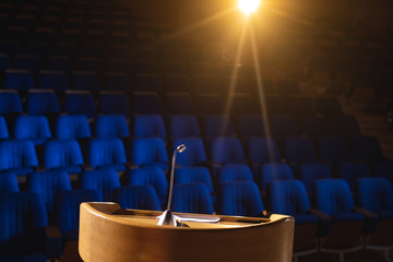 Empty auditorium with podium and speaker on stage 