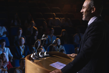 Businessman standing on a stage of auditorium for presentation
