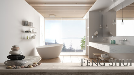 Fototapeta na wymiar Wooden vintage table shelf with pebble balance and 3d letters making the word feng shui over blurred minimalist luxury bathroom with bathtub and shower, zen concept interior design