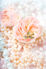 vintage bird pendant with letter, gentle pink rose and pearl beads. flower and jewels, pastel tones. Concept greeting cards for wedding, birthday, Valentine Day, Mother day. close up. shallow depth