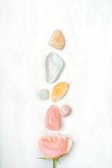 set gemstones crystal minerals for relaxation, meditation and rose flower. Magic Rock for Crystal Ritual, Witchcraft. Crystal Layout for Relaxing Chakra. Healing stones on white table. copy space