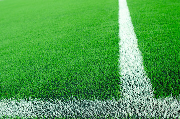 Artificial green grass with white stripe  on sports fields for soccer and football.