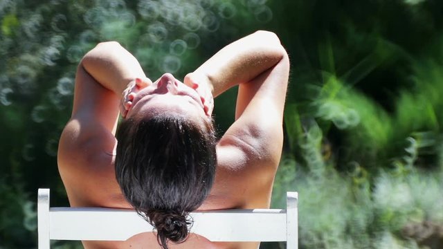 Beautiful young girl resting in a villa in the tropics. Woman takes sunbathing on vacation.