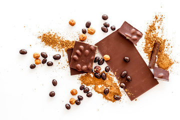 Chocolate with nuts and its ingredients on white background top view