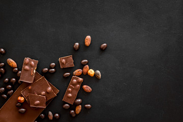 Cook homemade chocolate with bars, nuts, coffee beans on black background top view mock up