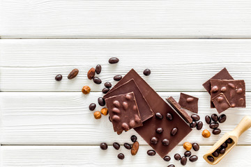 Cook homemade chocolate with bars, nuts, coffee beans on white wooden background top view mock up