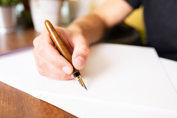 Writing with a pen. The man signs the document with a fountain pen.