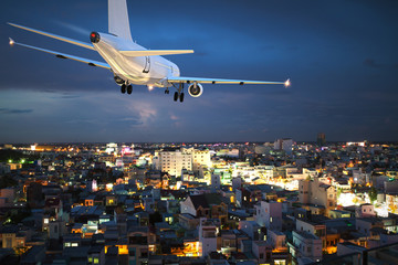 Flugzeug landet in der Nacht über der Stadt