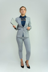 Full length studio portrait of a pretty young woman girl in a business suit on a white background...