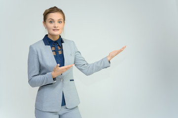 Studio photo a waist-high portrait of a pretty young woman girl in a business suit on a white background. He stands right in front of the camera, explains, with emotion.