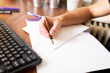 Writing with a pen. The man signs the document with a fountain pen.