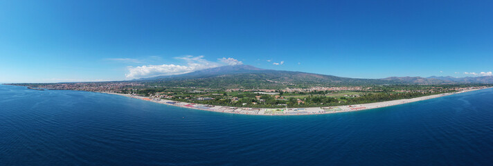 Veduta in estate della spiaggia di Fondachello con sfondo sul vulcano  Etna in Sicilia