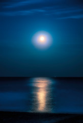 Fototapeta na wymiar Moonlit night over the sea. Full moon and lunar pathover the sea. Full moon and lunar path