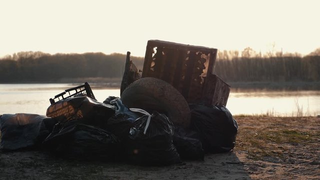 Lots of garbage, old stuff, on the beach at sunset. Environmental pollution.