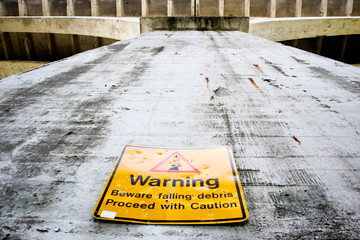 warning falling debris under old bridge