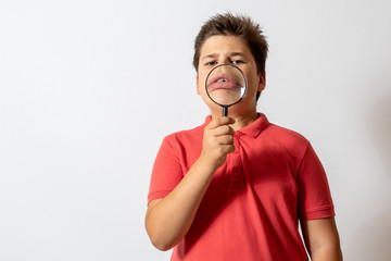 A boy with a magnifying glass. The child plays detective