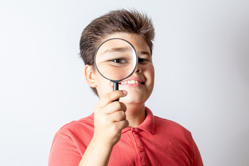 A boy with a magnifying glass. The child plays detective