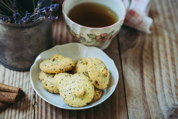 Gouter avec thé citron et biscuits sans gluten à la cannelle, fond bois vintage et pot en métal avec de la lavande