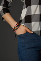 Cropped shot of a female wrist with a multilayer leather bracelet made of wax ropes and leather...