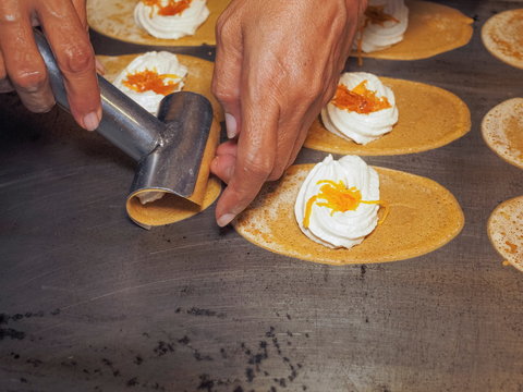 Khanom Thungtag (Sweet Thai Pancake) cooking on hot pan, Thai dessert Flour and coconut milk with yeast, salt and sugar mixed into a pancake, mixed with foi tong.