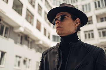 Portrait of Stylish Young Man in Black Leather Jacket and Hat