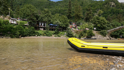 Yellow inflatable boat on the river or lake near the shore in a clear summer day. Tourist...