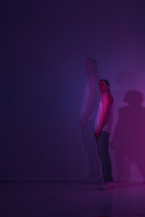Guy is a hip hop dancer in a Studio with colored light. Double exposure photo