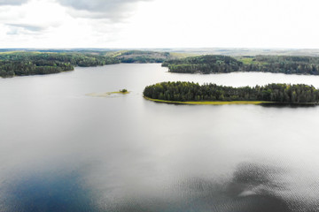 Aerial view of lake with island and forest on a summer cloudy day in Finland. Drone photography