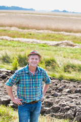 Fototapeta premium Portrait of Happy mature farmer standing in field