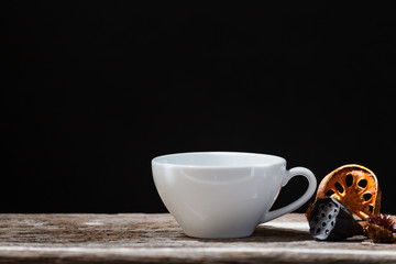 Selective focus of white cup dried quince and cinnamon sticks on wooden dark background