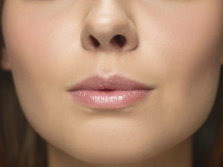 Fototapeta premium Close-up portrait of young woman's face. Female model with well-kept skin and big lips. Concept of women's health and beauty, cosmetology, cosmetics, self-care, body and skin care. Anti-aging.