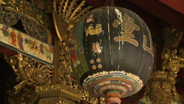 Extreme close-up low-angle still shot of decorated traditional Chinese lanterns hanging on Khoo Kongsi ceiling, Georgetown, Penang, Malaysia