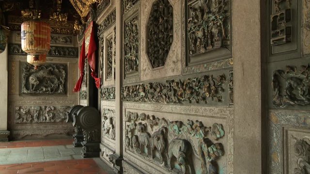 Close-up low-angle still shot of artistic wall carvings, sculptures, and decorations on the walls of Leong San Tong Khoo Kongsi, Georgetown, Penang, Malaysia