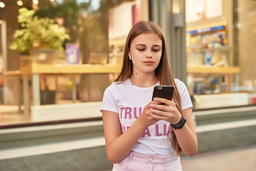 Fototapeta na wymiar teen girl with a phone near a shop window