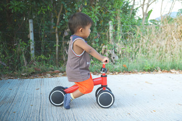 Boy playing a bicycle using a plowed leg is a bike