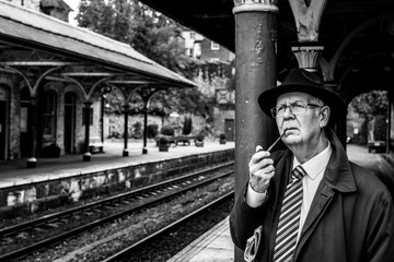 Awaiting his train to Leeds, the Yorkshire businessman smokes his pipe.